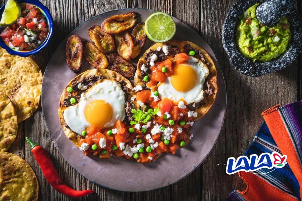 Disfruta el desayuno con estos huevos motuleños y Lala.